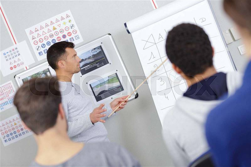 Teacher working through flip chart with students, stock photo