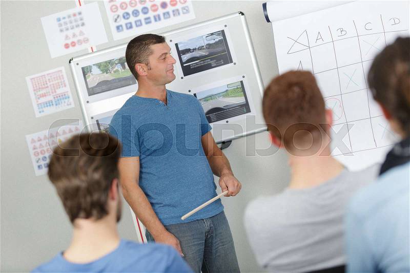 Teacher at front of class training group, stock photo