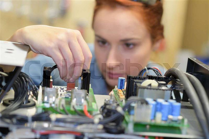 Woman working on electrical system, stock photo