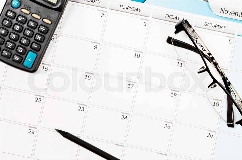 Calendar schedule on work table and calculator, pencil, eye glasses, stock photo