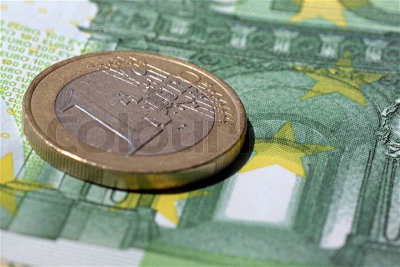 One euro lying one one hundred euro banknote, stock photo