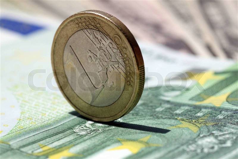 One euro coin on a one hundred euro banknote, stock photo