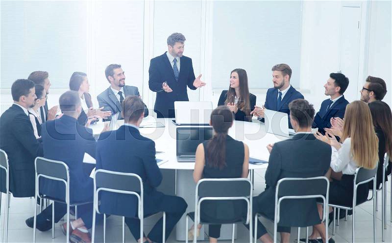 Cheering business team and smiling commercial Director to close the business meeting in the spacious office at the round table, stock photo