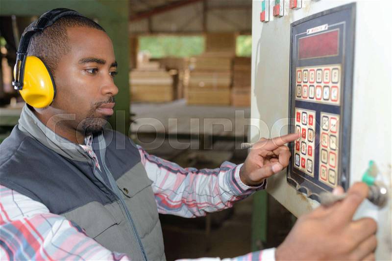 Man entering code into electrical box, stock photo