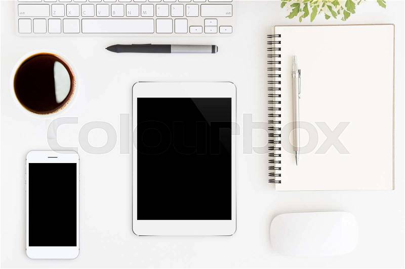 Tablet showing blank screen on white work desk top view, stock photo