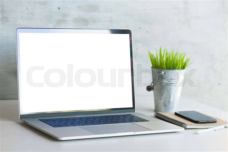 Laptop computer on work desk showing white blank screen, stock photo