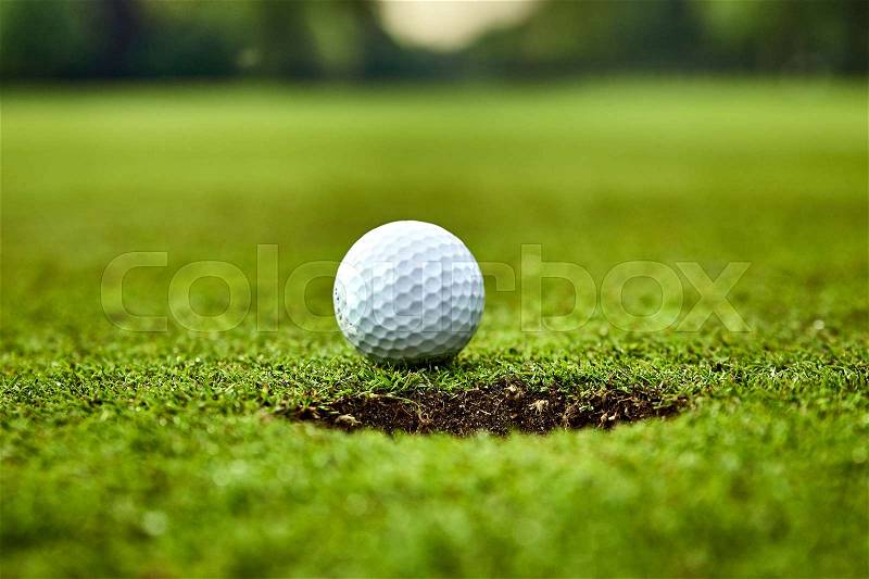 Golf ball on the green. golf ball on lip of cup, stock photo