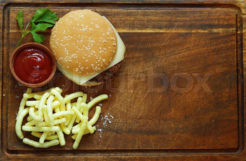Fast food burger with french fries on a wooden board, stock photo