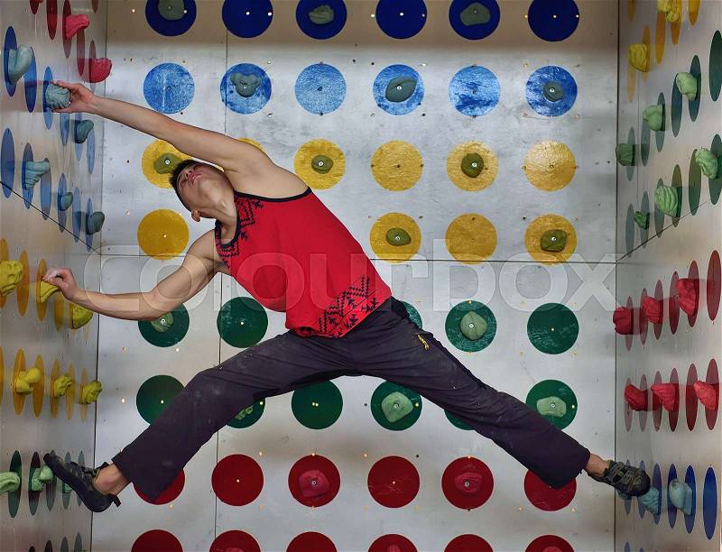 Young Climberman playing in climber twister game, stock photo