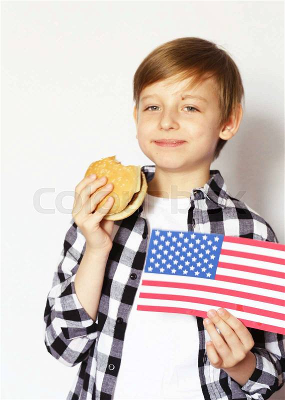 Cute blonde boy eating cheeseburger - American food, stock photo