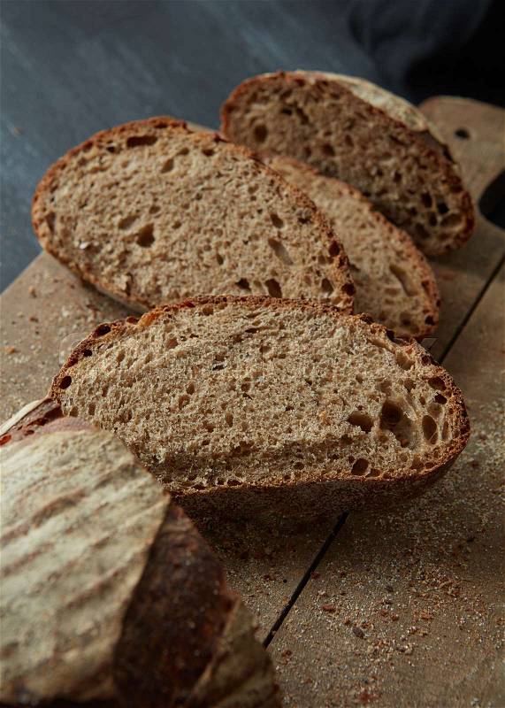 Sliced rye bread on cutting board closeup. The cut rye bread on wooden board brown. Healthy food. Proper nutrition. Bakery, stock photo