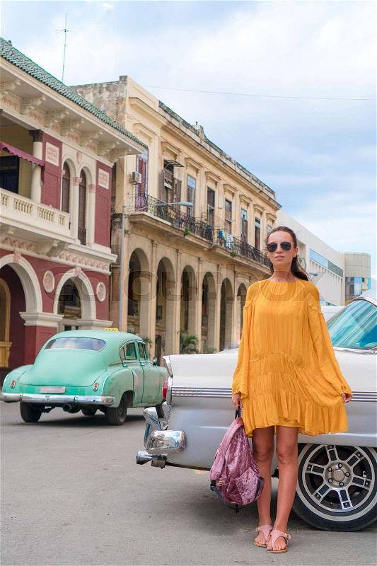 Happy woman in popular area in old Havana, Cuba. Young girltraveler smiling happy background colorful cars, stock photo