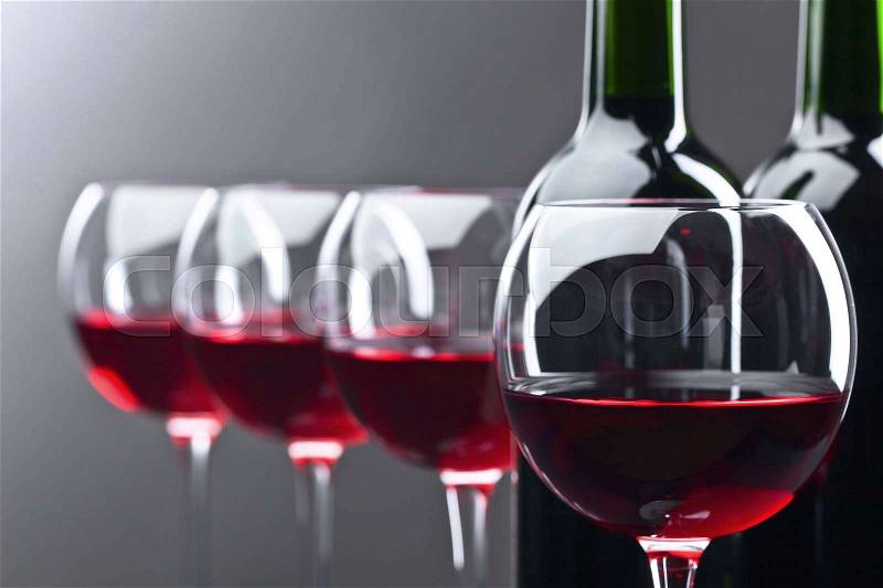 Bottles and glasses of red wine on a dark background , stock photo