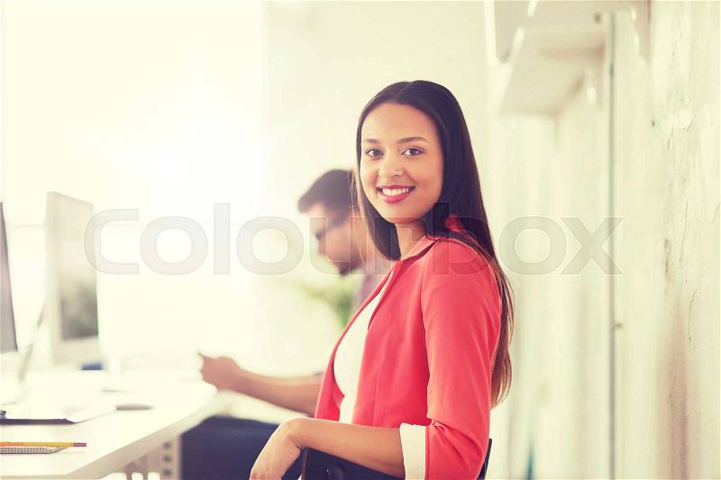 Business, startup, education and people concept - happy young african woman with computer working at office, stock photo