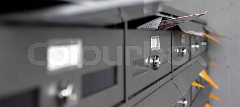 Mail boxes filled of leaflets and letters. Shallow DOF, stock photo