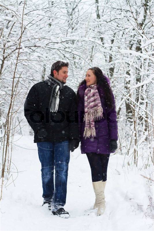 Young happy couple walking in winter park, stock photo