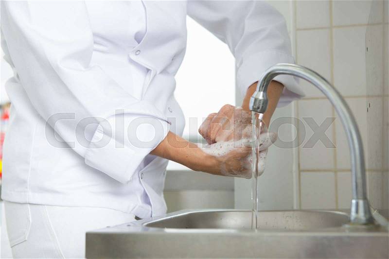 Person in white uniform soaping hands, stock photo