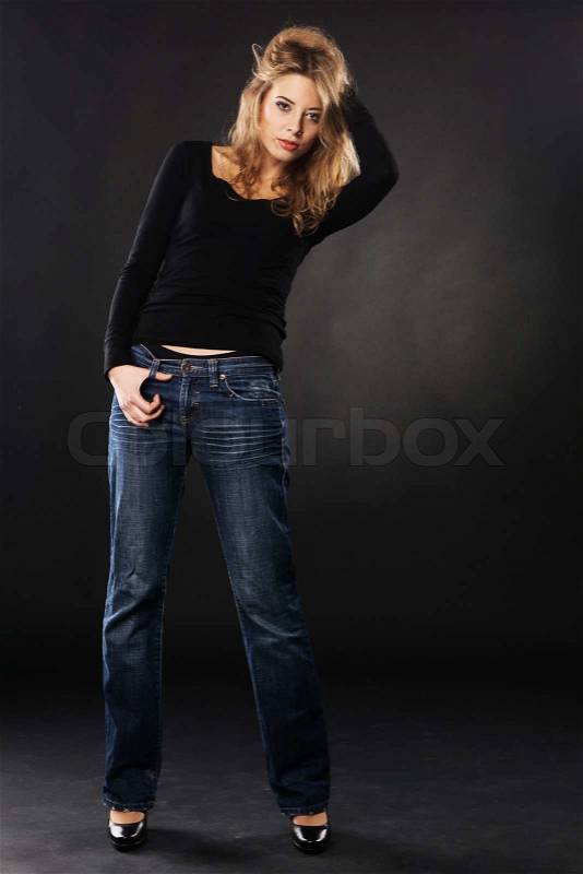Pretty model in casual clothing against black background, stock photo