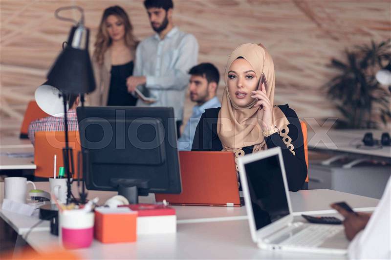 Young Arabic business woman wearing hijab,working in her startup office. Diversity, multiracial concept, stock photo