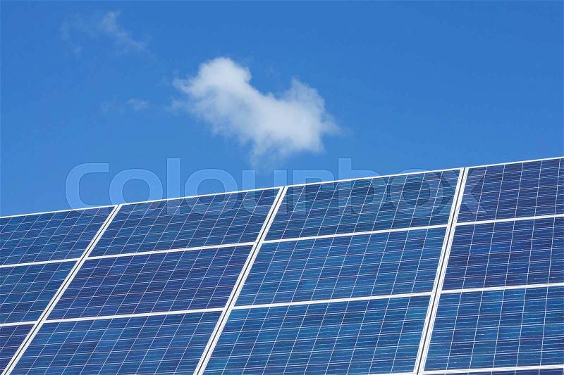 Solar panels and clouds against blue sky, stock photo