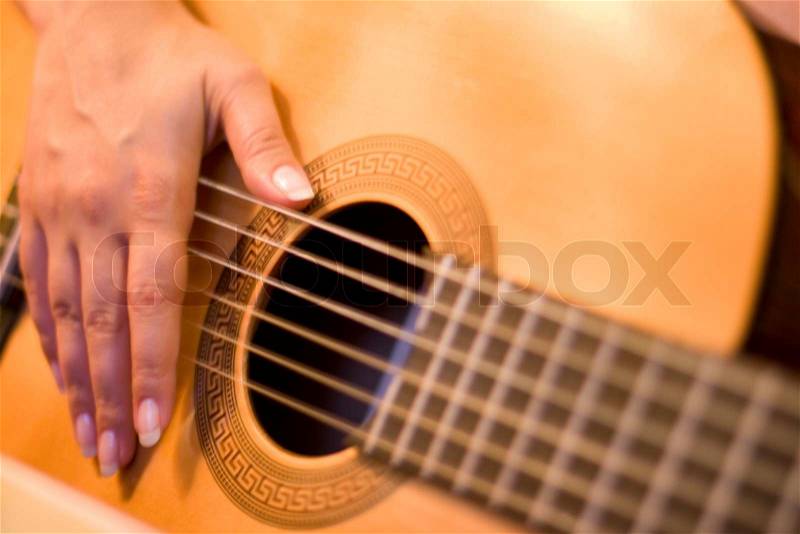 Woman plays solo on guitar, stock photo