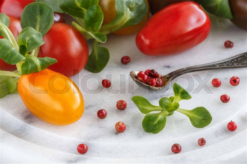 Cherry tomatoes and Peruvian pepper on marble background, stock photo