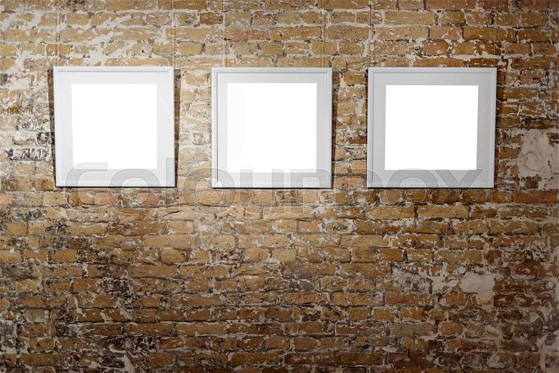 Three empty frames on light brick wall. Blank space posters or art frame waiting to be filled. Square Black Frame Mock-Up, stock photo