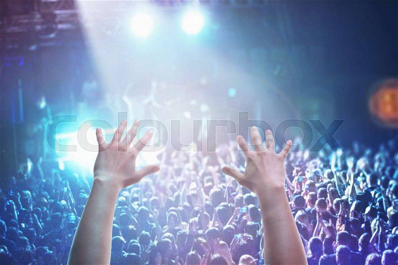 The silhouettes of concert crowd in front of bright stage lights. Concert of an abstract rock band, stock photo