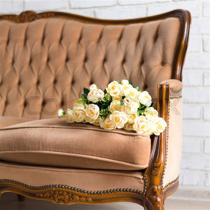 Bouquet of rose flowers on ancient vintage sofa, stock photo