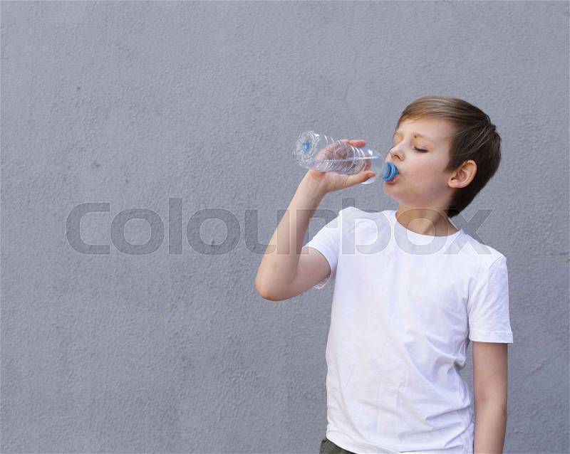 Blonde boy drinking clean water. Healthy lifestyle, stock photo