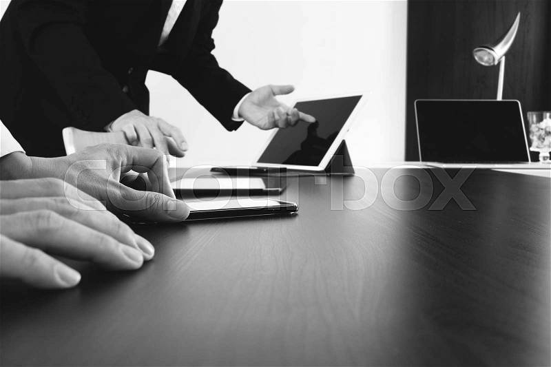 Co working team meeting concept,businessman using smart phone and digital tablet and laptop computer in modern office,black and white, stock photo