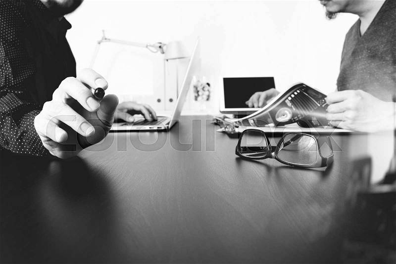 Business team meeting.Professional investor working new start up project and digital tablet docking keyboard and laptop computer with smart phone using and eyeglasses in modern office,black and white, stock photo