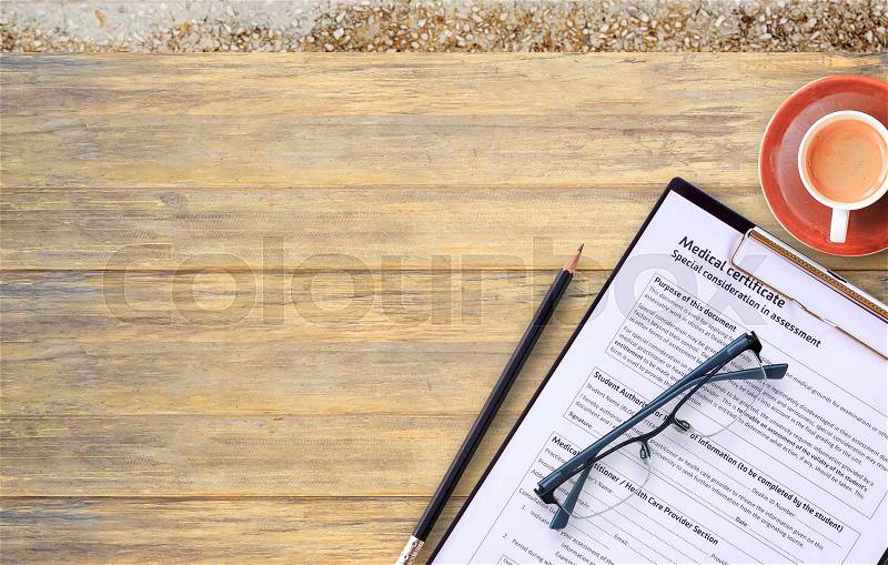 Workplace of a doctor.Medical certificate form,glasses,pencil with coffee cup on wooden desk background. Top view with copy space. Health concept, stock photo