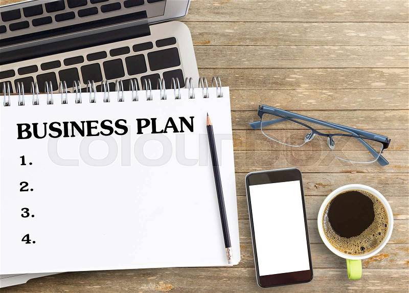 Flat lay, BUSINESS PLAN concept with laptop,smart phone,cup of coffee and glasses on office desk. top view with copy space for design, stock photo