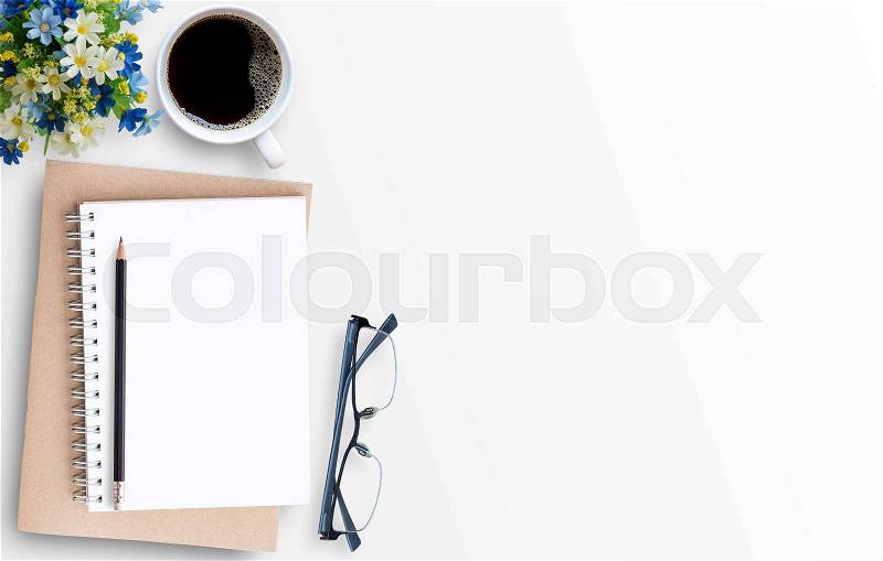 White minimal office desk table with notebook,glasses,pencil,and cup of coffee. Top view with copy space for text or picture, flat lay, stock photo