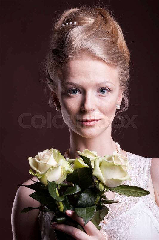 Portrait of blonde woman in victorian dress with roses in hands. Rich and vintage. Luxury and elegance. Studio photo, stock photo