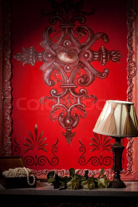 Rich red victorian interior with a lamp on fireplace. Luxury annd vintage, stock photo