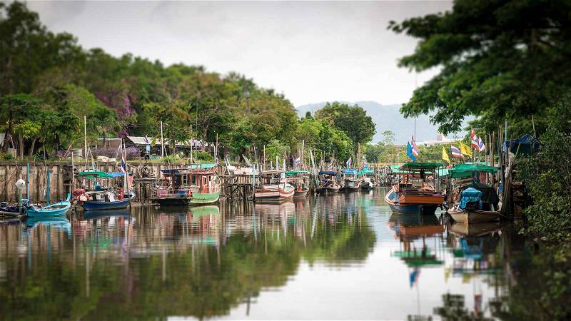 Tilt-shift blur effect. Scenery of fishing boats in canal, Phuket, Thailand, stock photo