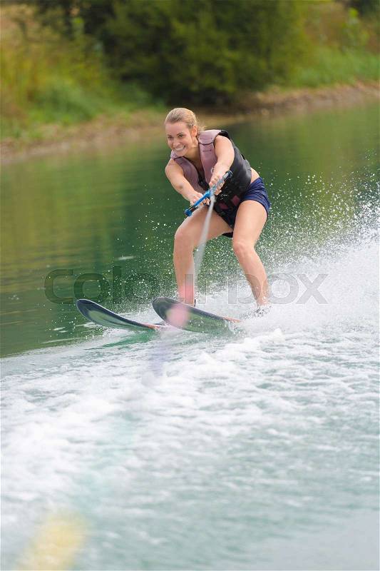 Happy young girl on a water ski, stock photo
