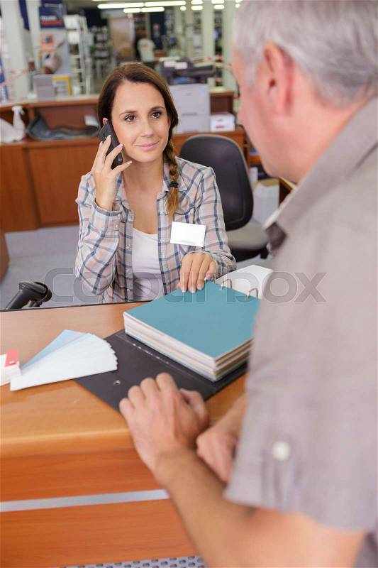 Store clerk giving assistance to a customer at a store, stock photo