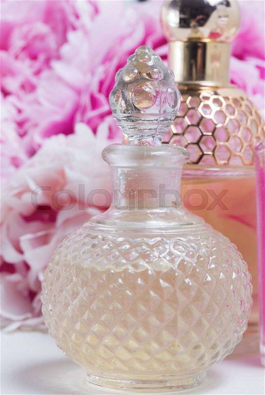 Peony essence in glass vials and fresh peony flowers, stock photo