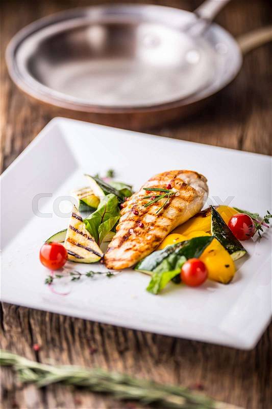 Grill chicken breast. Grilled vegetables with chicken breast. Grilled chicken with vegetables on oak table, stock photo