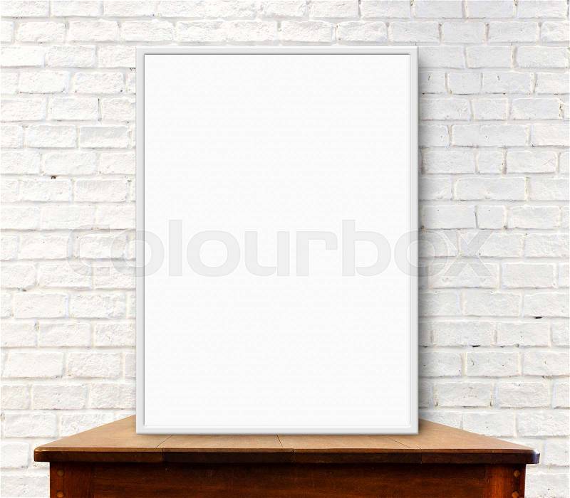 White frame mock up on the wood table at white brick wall, stock photo