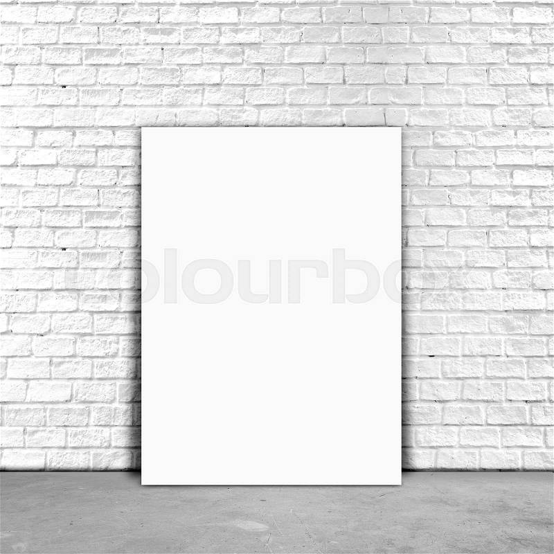 Blank Poster paper standing next to a white brick wall, stock photo