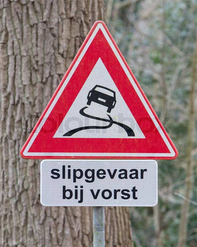 Road sign warning against slippery road due to snow ice (dutch), stock photo