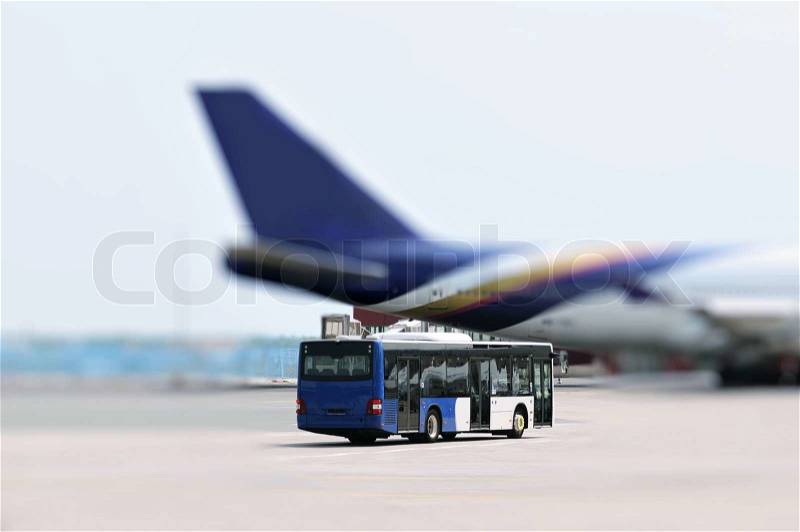 This photograph represent an Airport bus and plane, stock photo