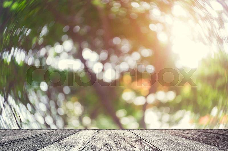 Wood table with blurred nature background. Abstract blurred tree with sunlight and wood shelf product display.Empty perspective wood table and space with green nature blur background.Vintage filtered, stock photo