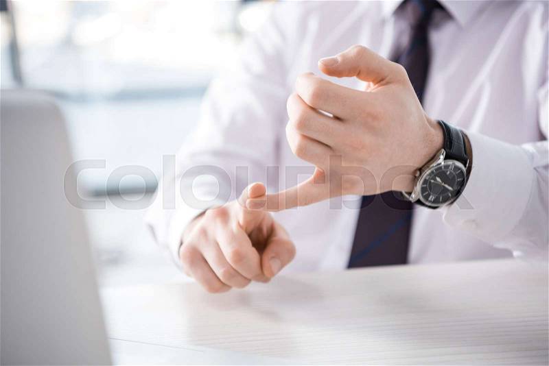 Partial view of businessman counting on fingers at workplace, business concept, stock photo