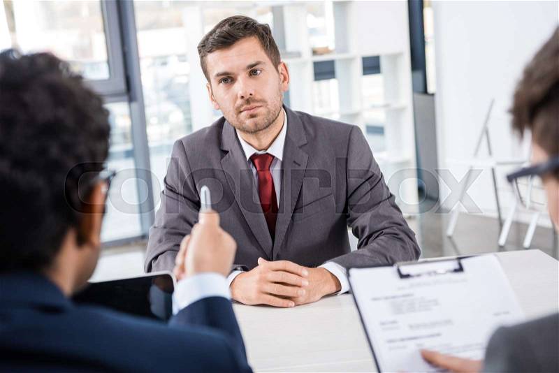 Attentive businessman listening to colleagues during job interview, business concept , stock photo