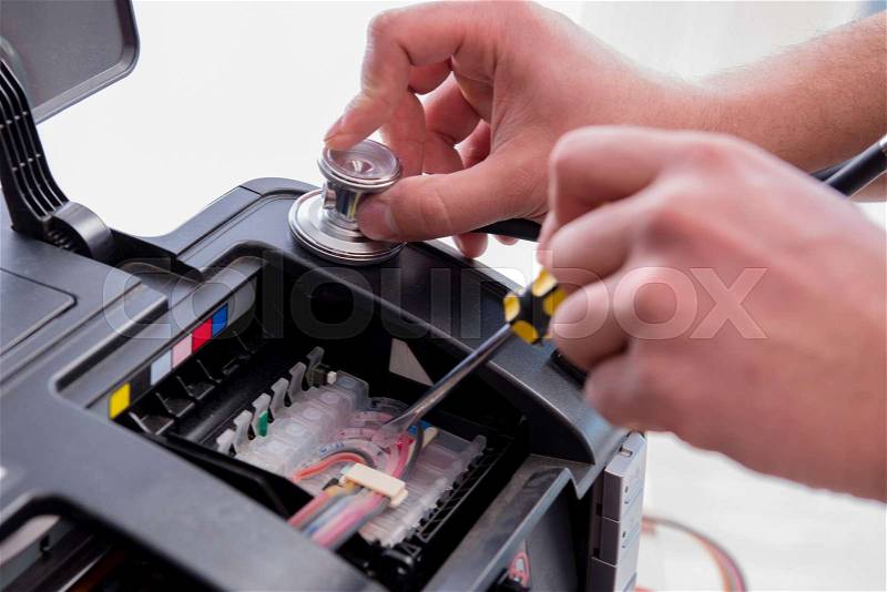 Repairman repairing broken color printer, stock photo